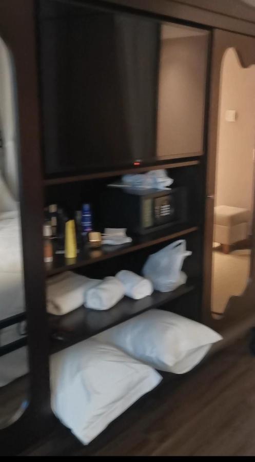 Buona Vitta Gramado Resort & Spa By Gramado Parks Екстериор снимка The photo shows a piece of furniture, likely a shelving unit or cabinet, with several items on it. There is a television mounted on top. Below the TV, there is a microwave and a small safe. The shelves contain various toiletries and personal care pro