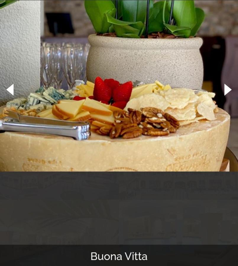 Buona Vitta Gramado Resort & Spa By Gramado Parks Екстериор снимка The photo displays a beautiful cheese platter. It features a large round cheese wheel as the base, surrounded by various types of cheeses including soft and hard varieties. There are also some crackers or crisps, along with nuts, particularly pecans.