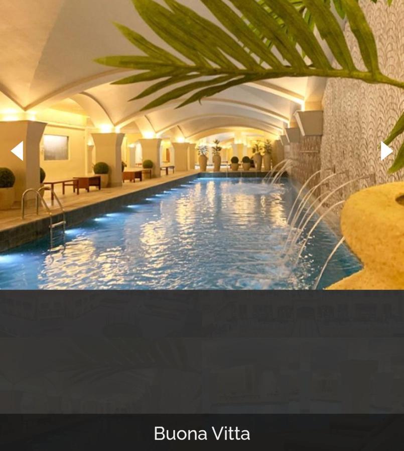 Buona Vitta Gramado Resort & Spa By Gramado Parks Екстериор снимка The photo depicts an elegant indoor swimming pool area. The pool is illuminated with lights along its edge, and there are gentle water features creating a calming atmosphere. The ceiling has an arched design, and the space is decorated with plants an