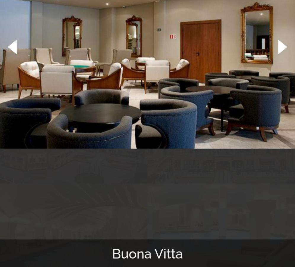 Buona Vitta Gramado Resort & Spa By Gramado Parks Екстериор снимка The photo shows a modern, elegantly designed lounge or waiting area. It features several circular seating arrangements with dark blue armchairs surrounding black tables. In the background, there are light-colored lounge chairs and a wooden door leadi