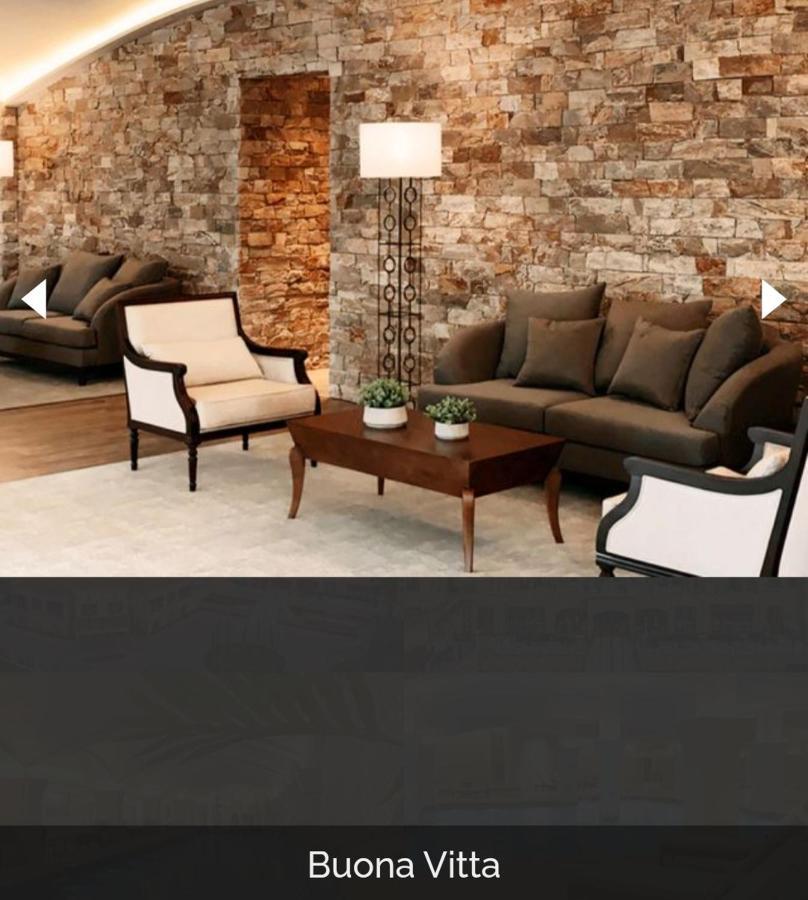 Buona Vitta Gramado Resort & Spa By Gramado Parks Екстериор снимка The image shows a stylish living room setting. There are two sofas: one is a dark brown color, and the other is a cream color with dark wooden accents. In the center, there is a wooden coffee table with a smooth finish and decorative plants on top. T