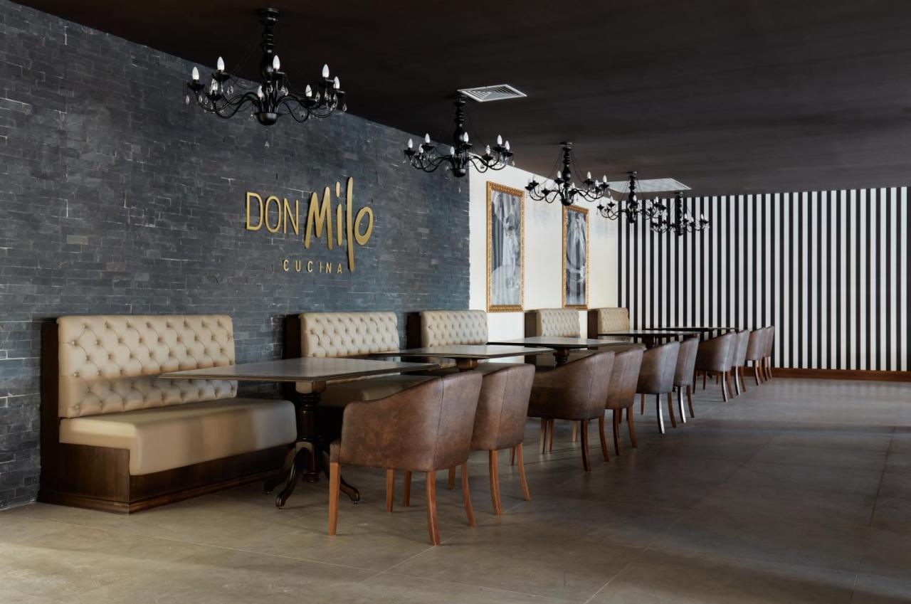 Buona Vitta Gramado Resort & Spa By Gramado Parks Екстериор снимка The photo showcases an interior of a restaurant named "Don Milo." The design features a modern and sophisticated look with a mix of textures and colors. 

On one side, there are upholstered booths in a neutral tone, creating a comfortable dining area