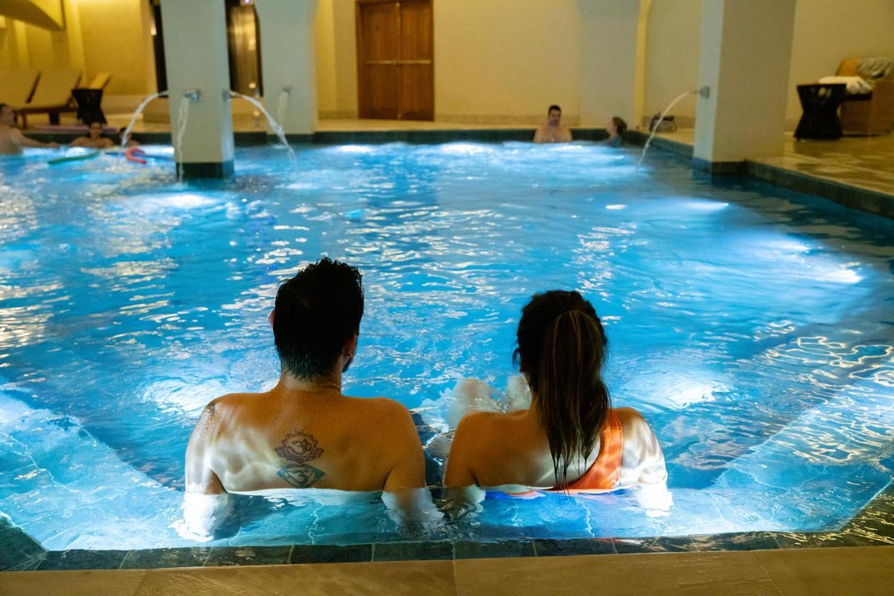 Buona Vitta Gramado Resort & Spa By Gramado Parks Екстериор снимка The photo shows a couple sitting in a swimming pool with gentle lighting. They are facing away from the camera, appearing relaxed and enjoying their time together. The water is illuminated with a soft blue light, creating a serene atmosphere. In the 