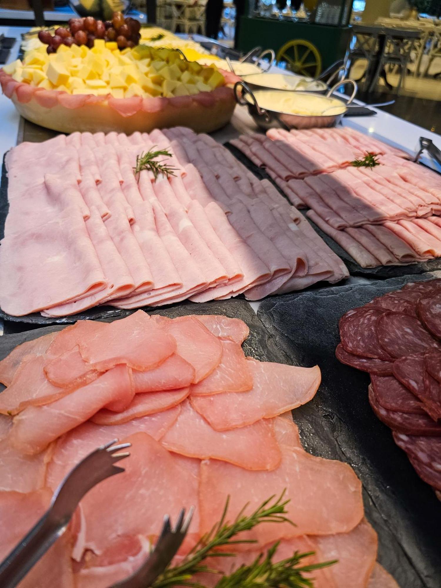 Buona Vitta Gramado Resort & Spa By Gramado Parks Екстериор снимка The photo shows a display of various types of sliced deli meats arranged on a flat surface. There are several layers of thinly sliced, pale-colored meats, likely including ham or turkey, organized neatly in parallel rows. Additionally, there are slic